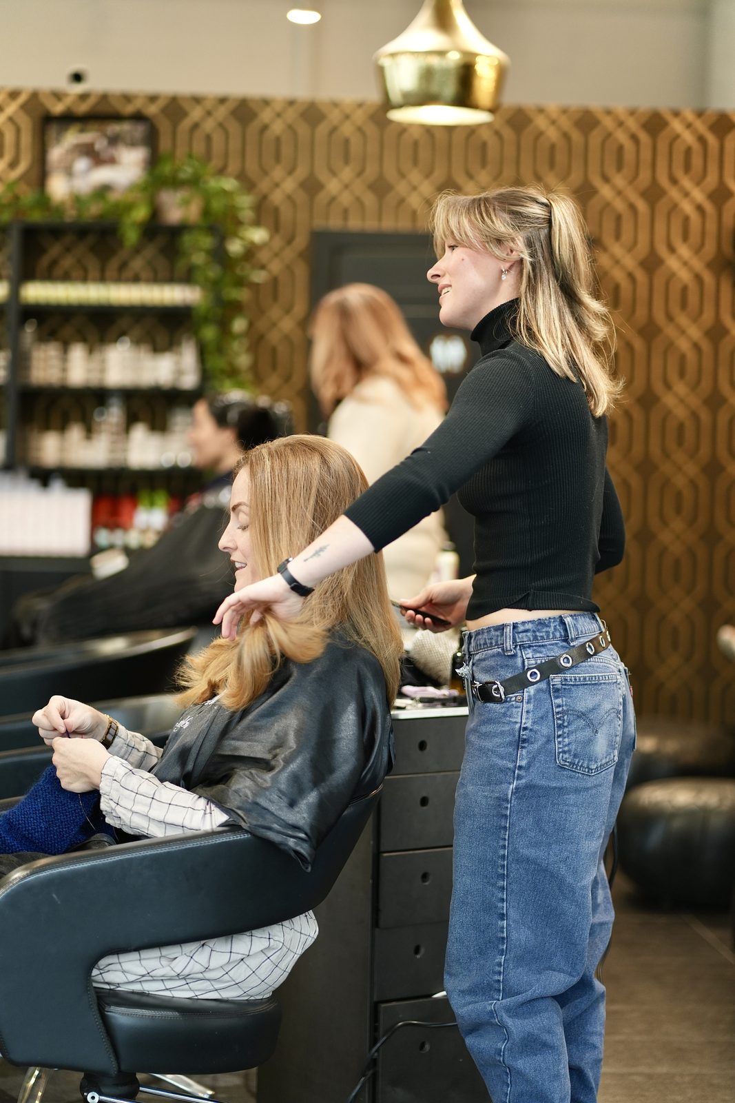 A stylist attentively caring for a guest at the wash basin