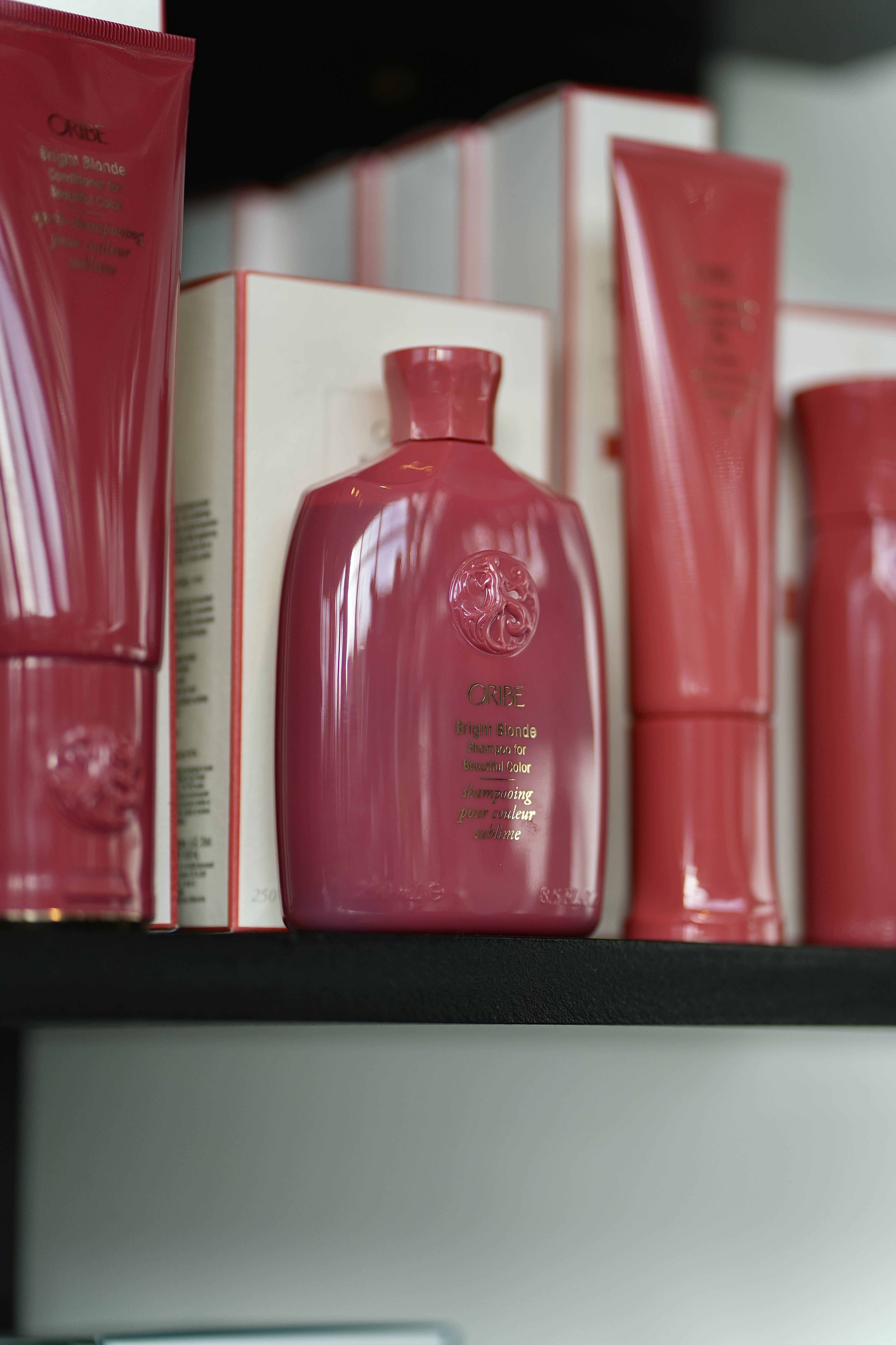 Detail of ORIBE products in deep red packaging on the Mod Salon shelf