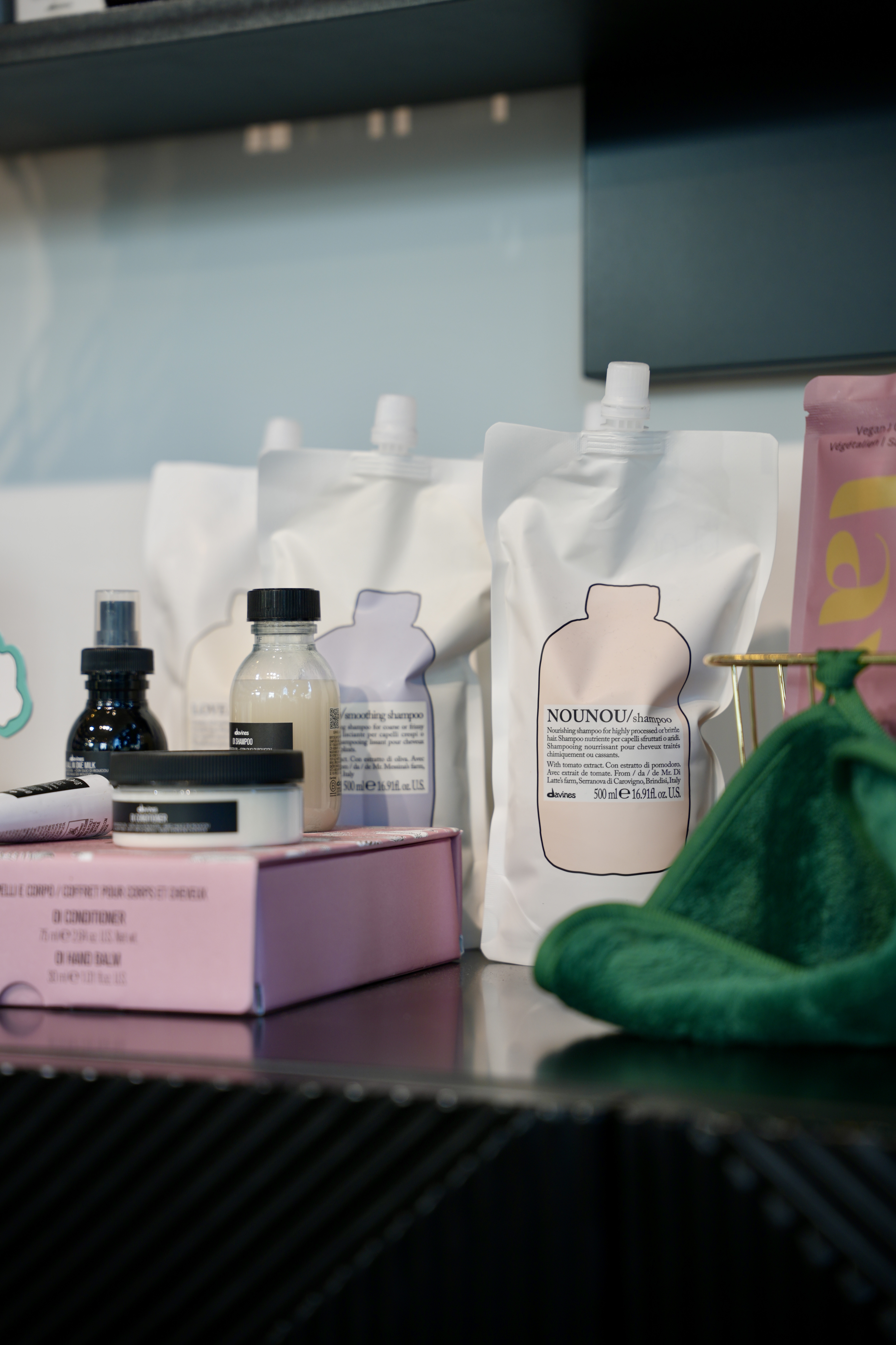 Davines NOUNOU and other professional products laid out on a black counter