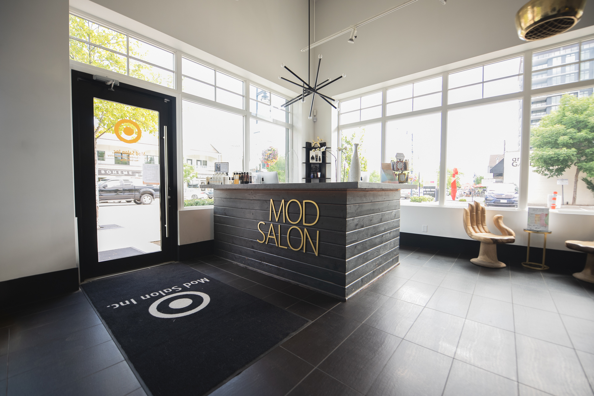 The reception desk inside MOD Salon, with carved gold signage and a circular brand mark on the floor