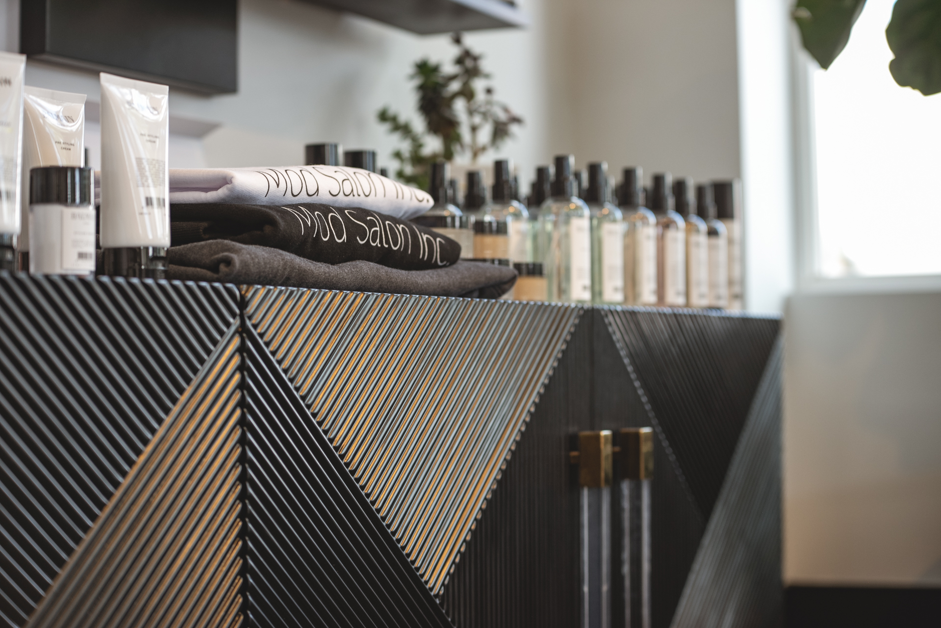Mod Salon Inc. branded merchandise on the textured wood retail display