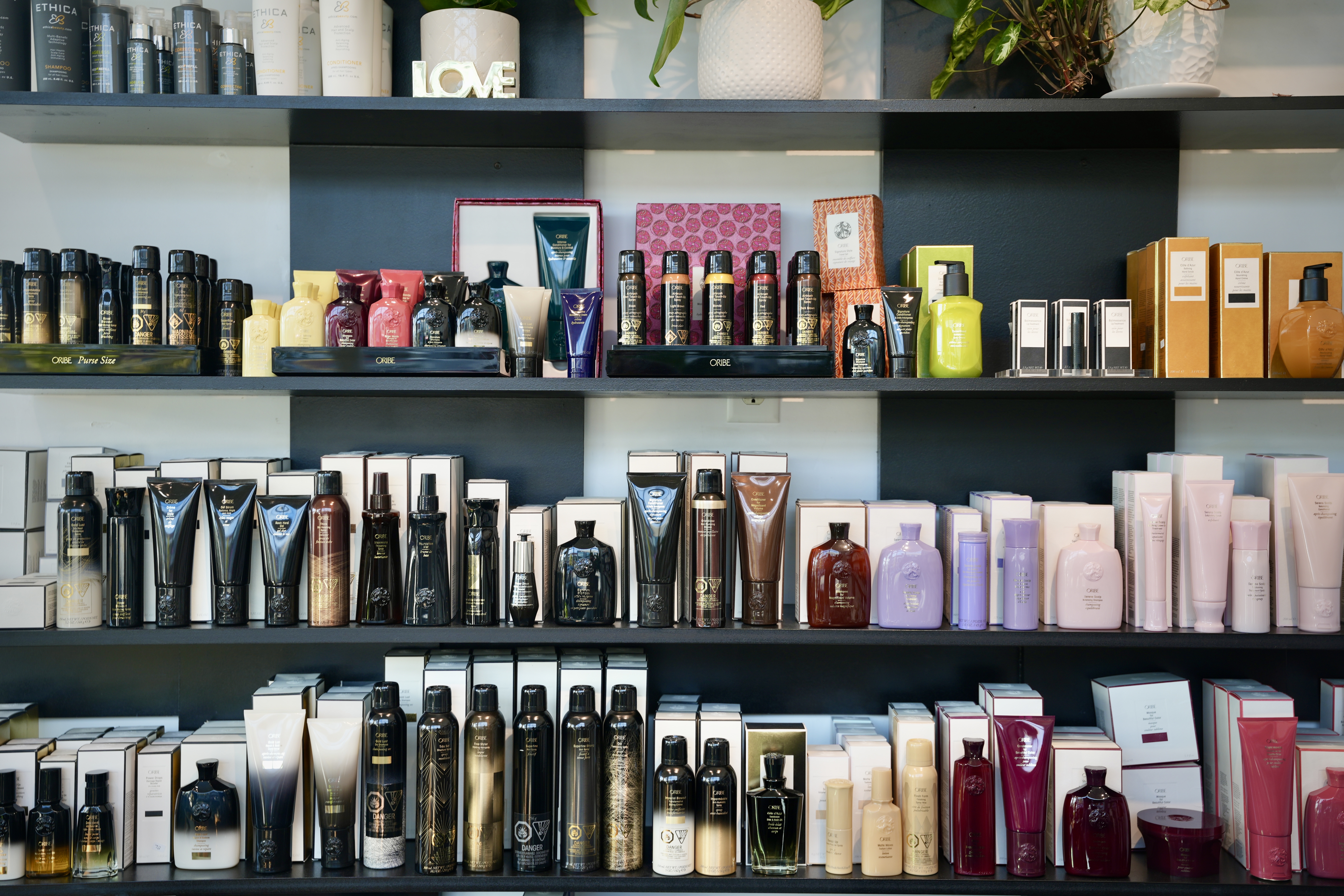 The full product retail wall at Mod Salon, showing a curated selection of professional shampoos, conditioners, and styling products